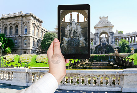 旅行概念在法国马赛Longchamp宫用移动装置拍摄喷泉照片的游客图片
