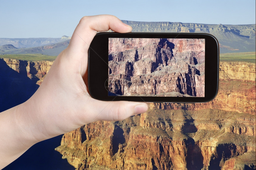 旅行概念在美国内华达州GrandCanyon市移动工具上拍摄岩石山照片的游客图片