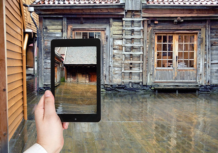 旅行概念在挪威卑根尔和的移动装置上拍摄雨水中木路人行照片的游客图片