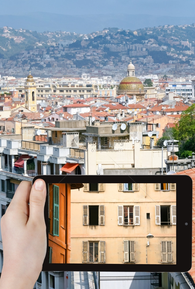 旅行概念旅游者用智能手机拍摄法国尼斯老城的房屋图片