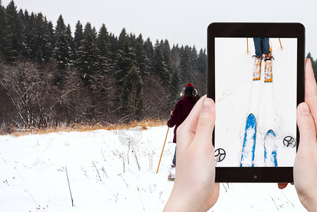 旅行概念旅游者拍摄广泛的跨滑雪和在地上用智能手机滑雪图片