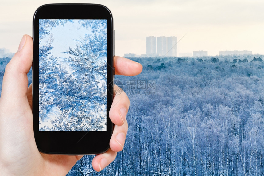 旅行概念旅游者拍摄雪花和玻璃霜的照片关闭智能手机图片