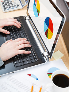 业务工作流程办公室工作人员用笔记本电脑运行在办公桌屏幕上显示图表图片