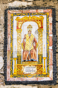 圣潘克拉斯或托尔米塔的潘克拉修斯圣齐奥修斯齐奥之圣托尔米纳镇在意大利西里城市住房墙上的圣陶尔米纳镇支持者背景