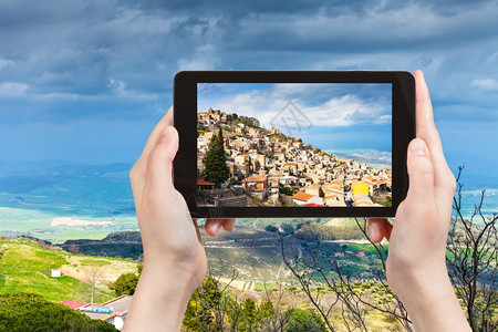 旅行概念游客拍摄意大利西里Aidone镇春季在平板电脑上的照片图片