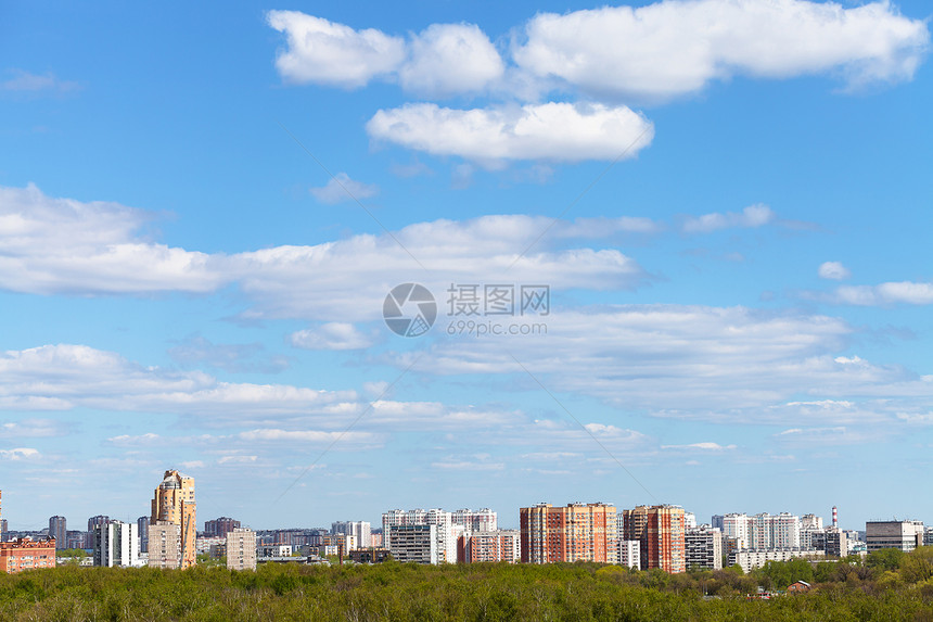 清蓝春空白天阳光明媚城市和绿林中白云笼罩着图片