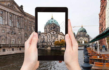 旅行概念游客用平板电脑在德国柏林拍摄斯布里河和柏林多姆的照片图片