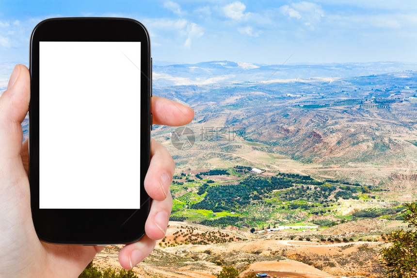 旅行概念旅游照片约旦尼博山用智能手机拍摄的约旦Nebo山承诺的土地用空白广告标志的屏剪图片