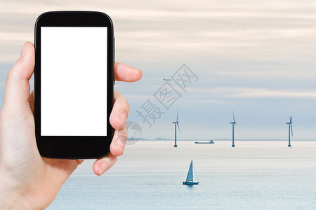 旅行概念旅游照片凌晨在丹麦哥本哈根附近的Middelgrunden离岸风力农场用智能手机拍摄用空白广告标志的屏幕截断背景图片