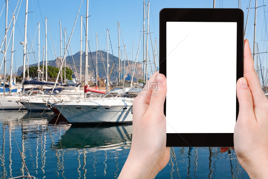 旅行概念在意大利巴勒莫旧港口用平板电脑在意大利巴勒莫的旅游摄影艇和船只用空白的广告标志屏图片