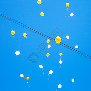 玩具气球在城市蓝色天空中漂浮图片