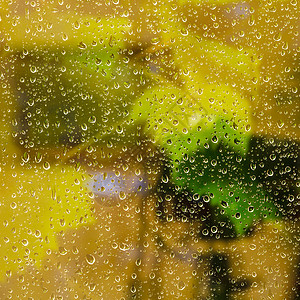 夜间下雨时窗帘上的滴产生黄色背景图片