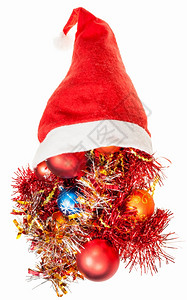 圣诞礼物xmas球和装饰品溢在白色背景的红圣塔帽上图片