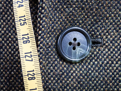 缝制测量磁带的裁缝和Tweed夹克上的扣图片