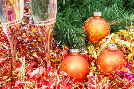 圣诞静生命两杯香槟盛满金色X马装饰品紧贴在圣诞树背景上图片