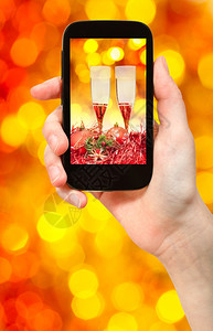 给人拍照圣诞节的死活两杯香槟红色和黄模糊的圣诞灯光bokeh背景图片