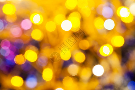 抽象的模糊背景黄和粉闪的圣诞光照亮Xmas树上电藻园图片