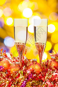 圣诞杯生命两香槟红和金的Xma装饰品黄色和紫模糊的圣诞灯布基背景图片