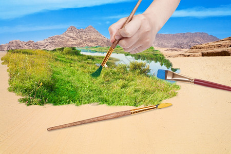自然概念季节和天气变化季节和天气变化手与油漆刷画沙漠中的绿草地图片