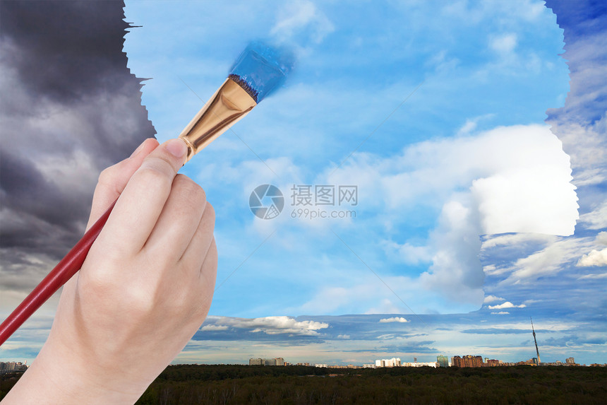 自然概念季节和天气变化手用油漆刷在城市的雨云上用蓝色天空图片