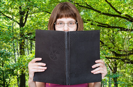 有眼镜的女孩读大书空白封面绿色夏月森林背景图片