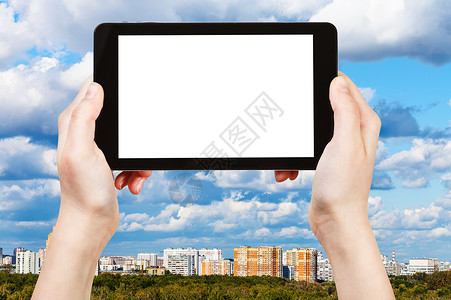 旅行概念手持平板电脑切除屏幕和上天线背景有蓝云图片
