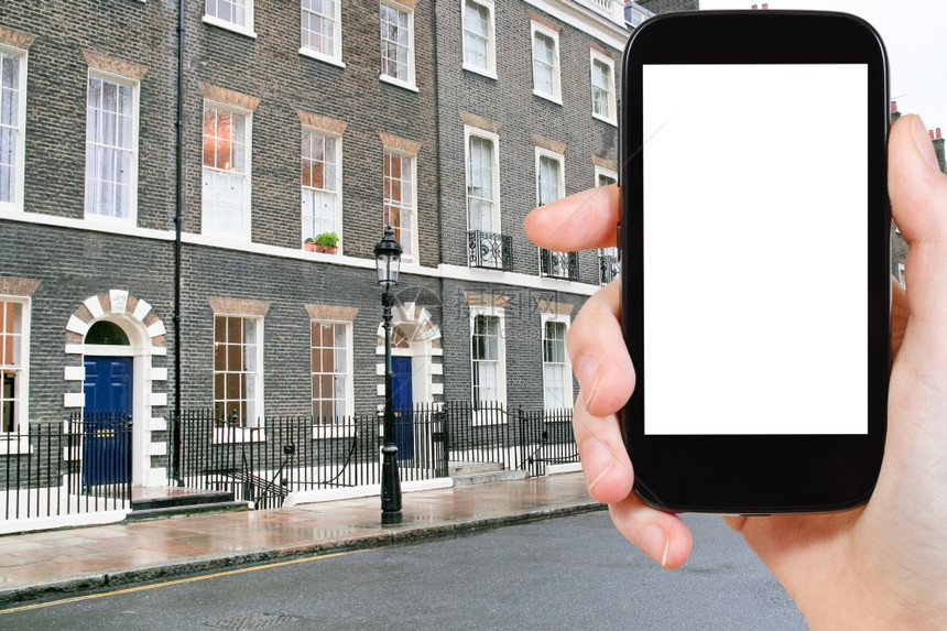旅行概念手持智能机用剪出屏幕的和背景伦敦公寓图片