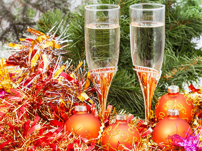 圣诞静生命两杯香槟圣诞树背景的金色X马装饰品图片