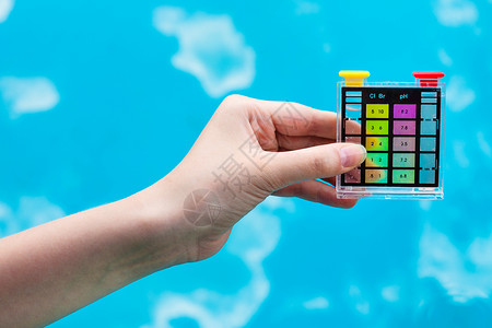 化学测试器量蓝色室外泳池中的pH水平图片