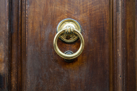 前往意大利在佛罗伦萨市的旧木门上敲铜环高清图片