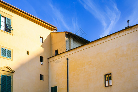 前往意大利蓝色天空下的黄公寓楼在阳光明媚的冬天佛罗伦萨市的蓝色天空下图片