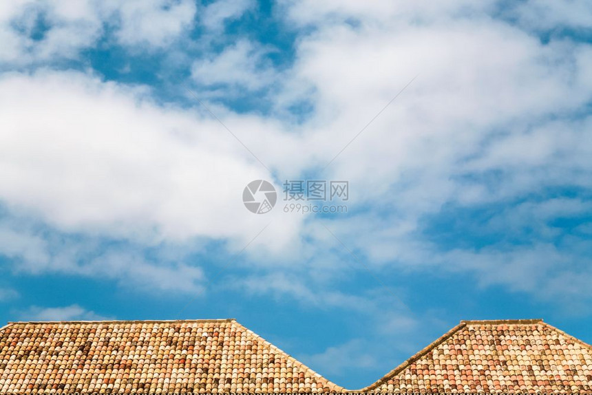 前往葡萄牙阿尔加夫蓝色天空中的白云在法罗市房屋的橙色瓷砖顶上图片