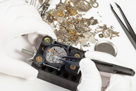 制表手由白色背景零件的tweezers修理机械手表背景图片