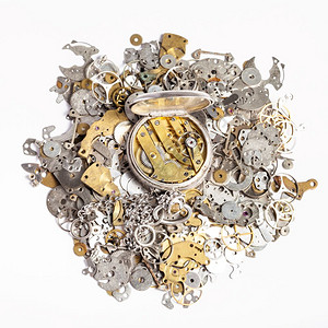 Watchmaker车间白底旧时钟备件堆积上打开银口袋手表的顶部视图图片
