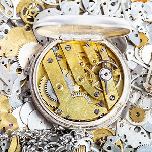 手表制作车间在钟盘备件堆上用黄铜时钟制作的银色口袋手表打开图片