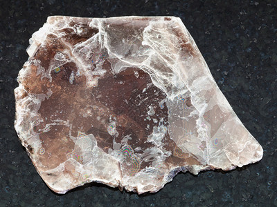 天然矿物岩标本的大型自然矿物岩石深花岗岩背景的粗棕色薄膜图片