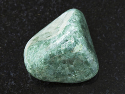 天然矿物岩标本的大型自然矿物岩石黑色花岗岩背景上的绿色玉石宝图片
