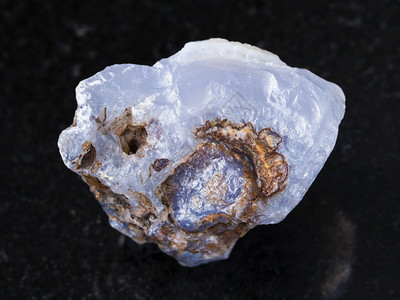 俄罗斯特兰斯贝卡利亚Zabaykalye天然矿物岩石样品的宏观拍摄深花岗岩背景上蓝玉髓宝石的原始晶体图片