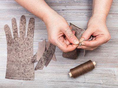 缝纫手套针妇缝制真正的皮手套图片