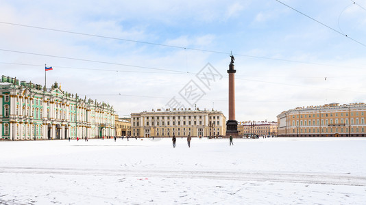 清晨在圣彼得堡市亚历山大柱和冬宫的雪覆盖广场全景图片