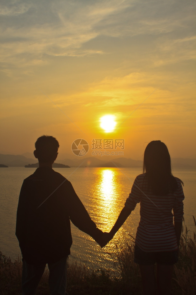 在湖边日落背景的情侣在爱图片