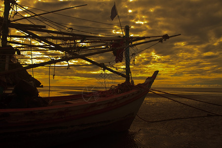 海滩和日落上的渔船图片