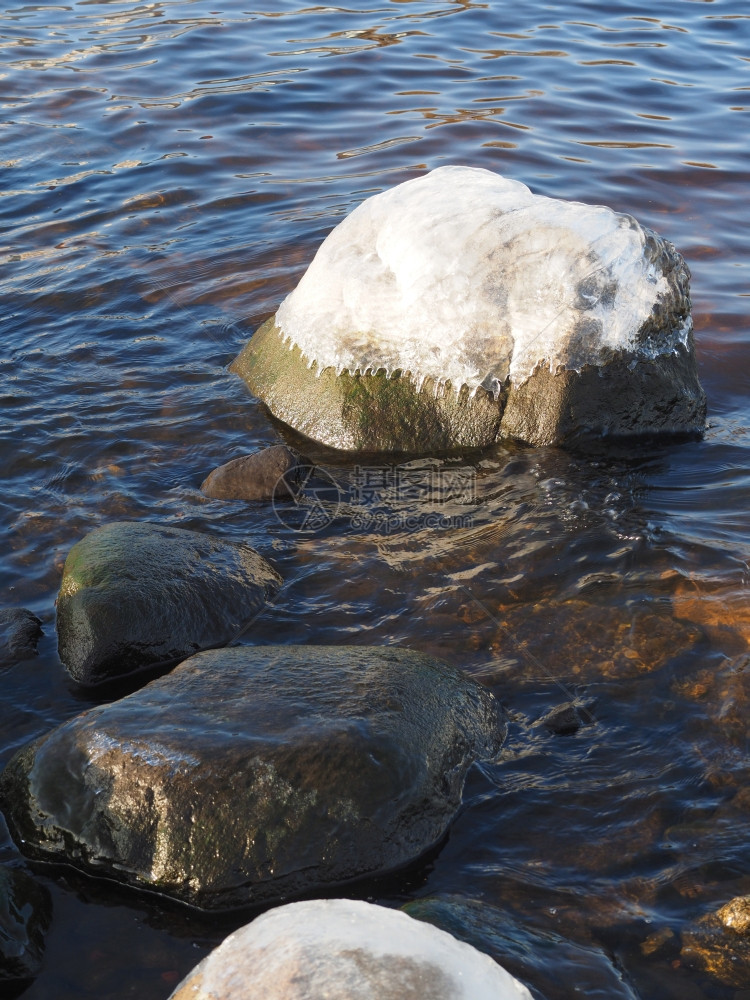 湖边冰块中的石头图片