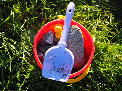 儿童桶和铲子在草地上图片