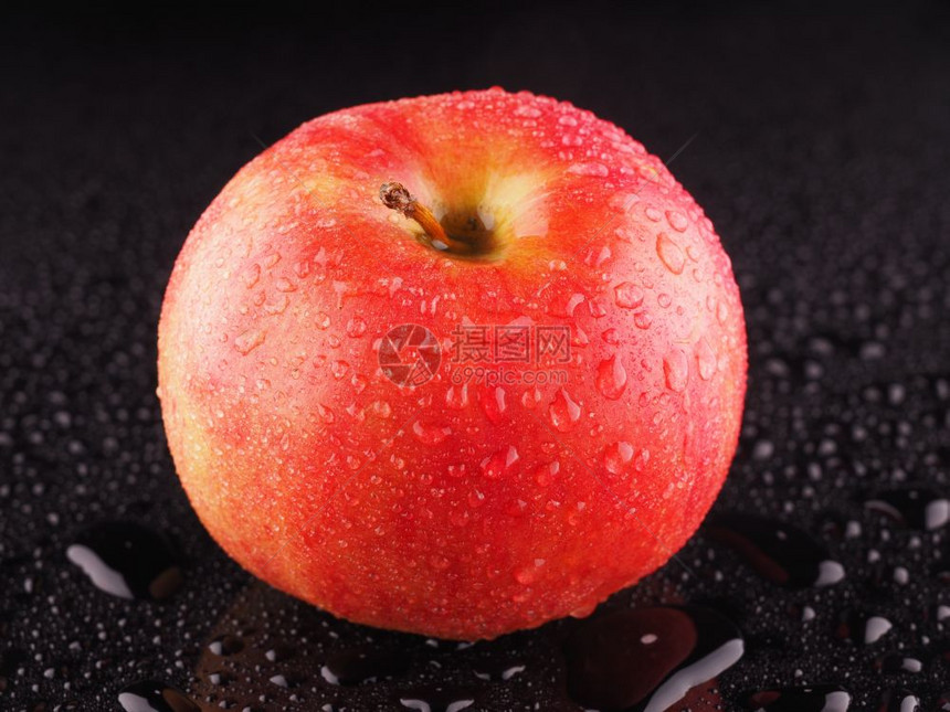 红苹果底暗背景带滴子的红苹果图片