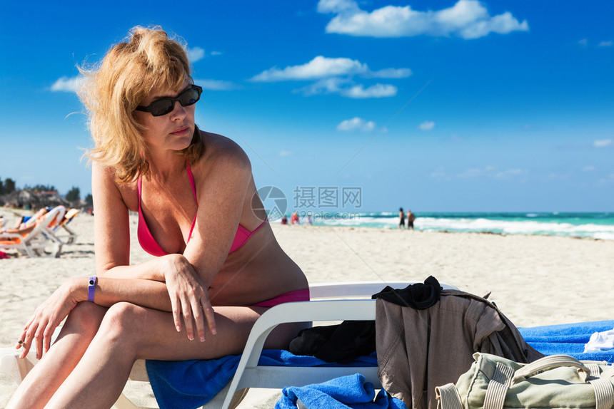 在阳光明媚的一天在海滩上的女人图片
