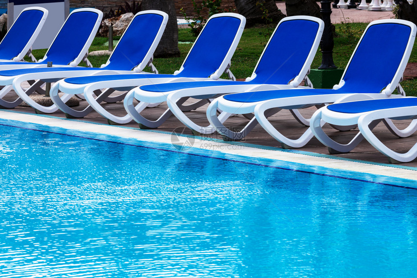游泳池旁的蓝色休息椅图片