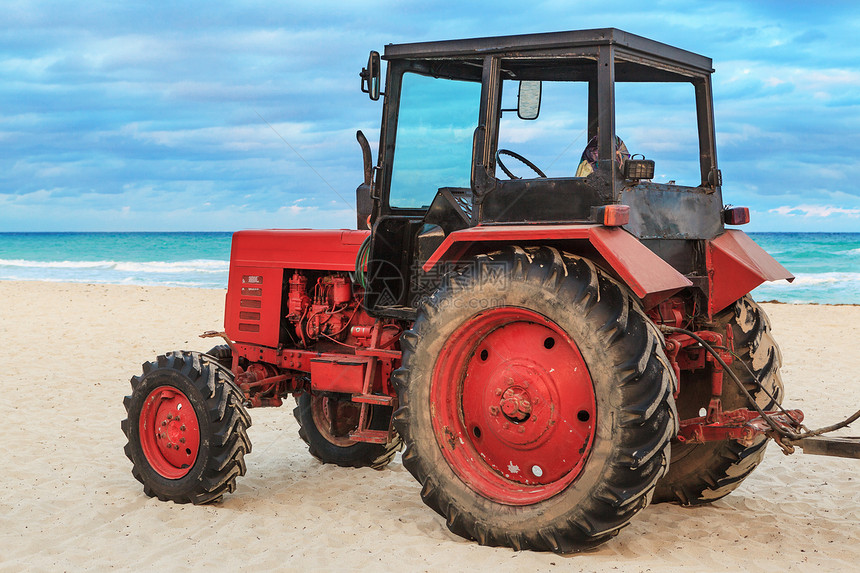沙滩上的旧红色拖拉机图片