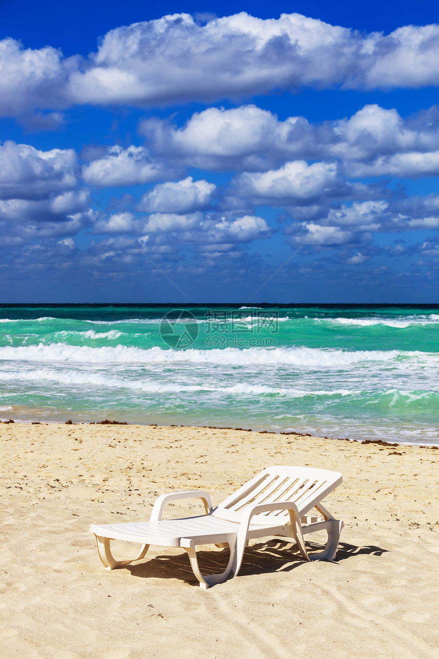 海洋背景沙滩上的甲板椅子图片