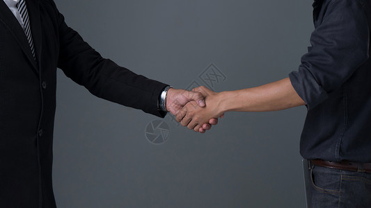 图像商人握手手在灰色背景下举行业务伙伴握手图片